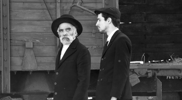 Black and white movie still of two Orthodox Jewish men in black hats and jackets