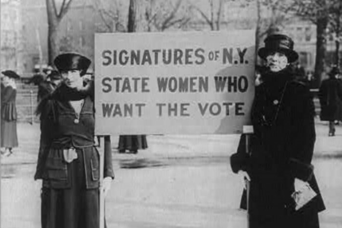 Black and white image of women suffragists holding signs in support of womens right to vote