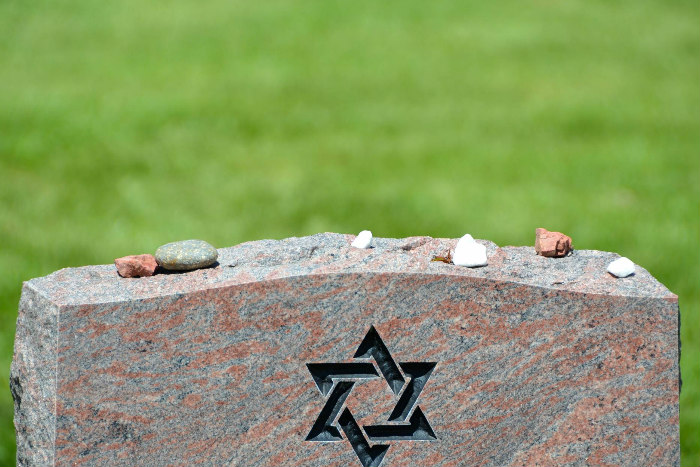 Headstone engraved with a Star of David with small stones on top