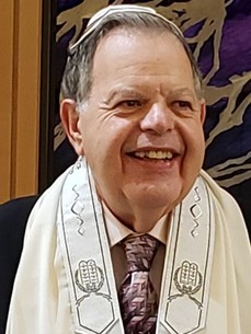 Dr Gary M Levin smiling while wearing a kippah and prayer shawl