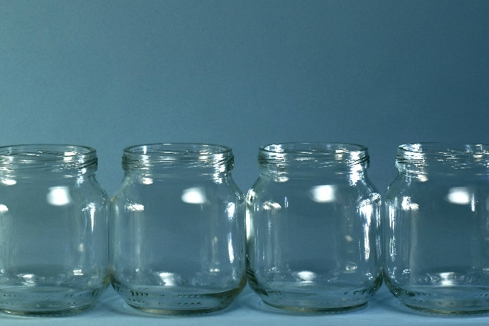 Empty baby food jars against a blue background