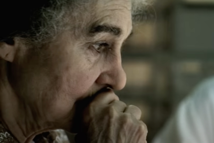 Lynn Cohen with her face in her hands as Golda Meir in a scene from Steven Spielbergs 2005 film Munich