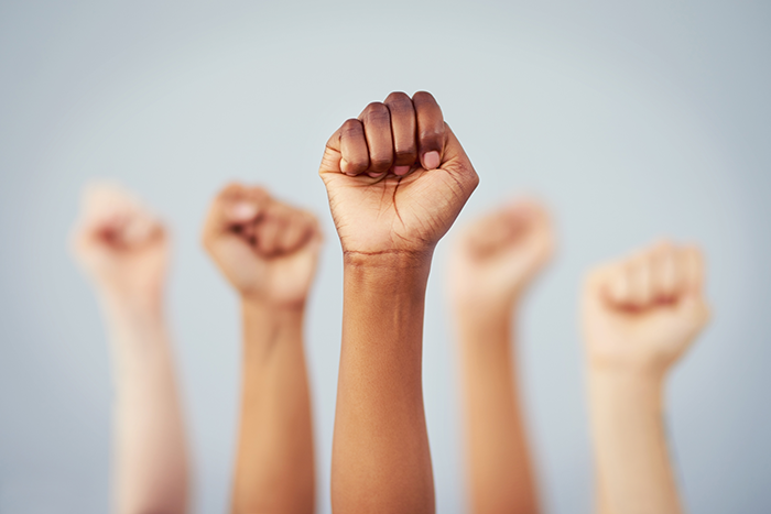 an image of five different skin toned fists in the air