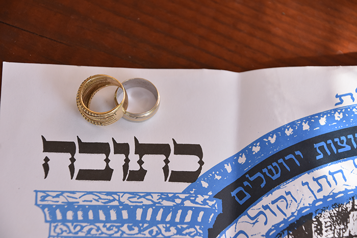 Photo of two wedding rings sitting on top of a Ketubah