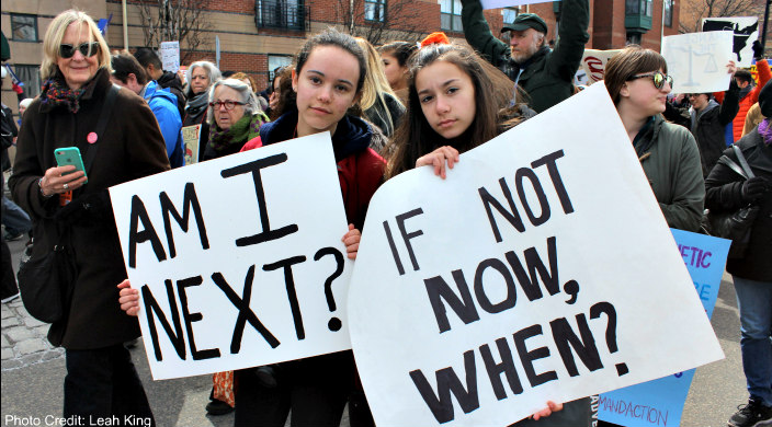 Two female students holding gun violence prevention signs at a march 