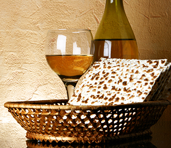 matzah in a basket with glass of wine and a wine bottle