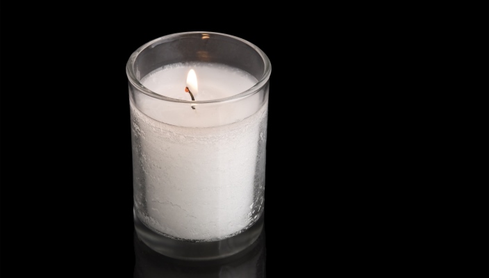 White Yahrzeit candle on black background