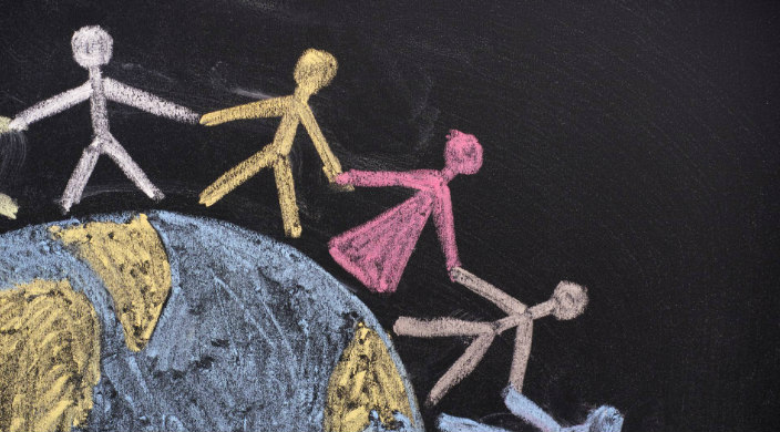 Chalk drawing of stick figures holding hands standing around the periphery of a map of the world