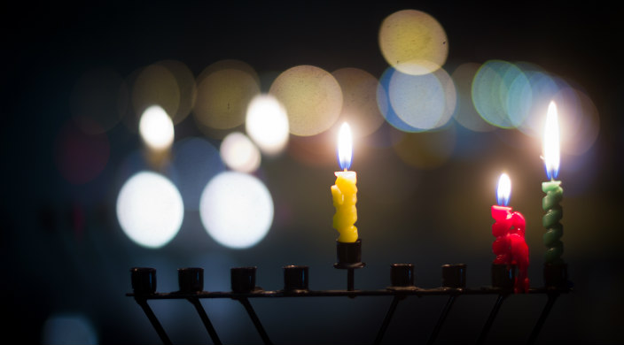 Lit Hanukkah menorah on second night of Hanukkah w/unfocused reflections of light in the background