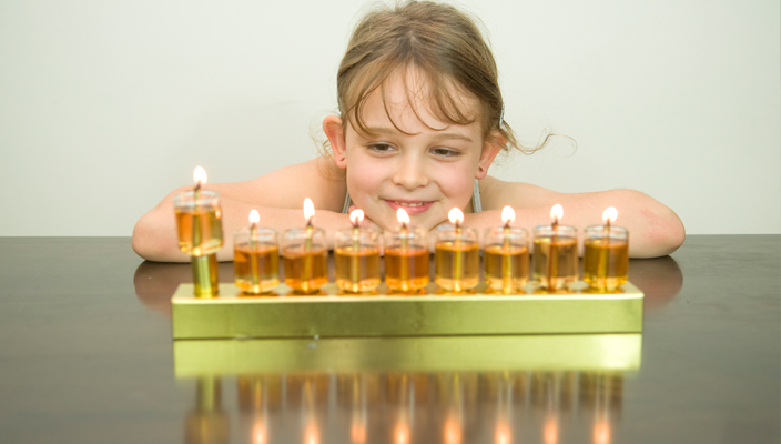 a girl admiring the Hanukkah menorah