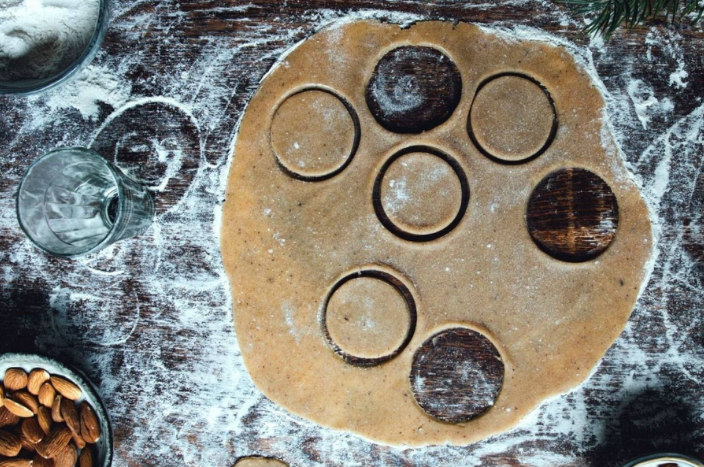Flattened dough with circular holes cut into it as if making cookies