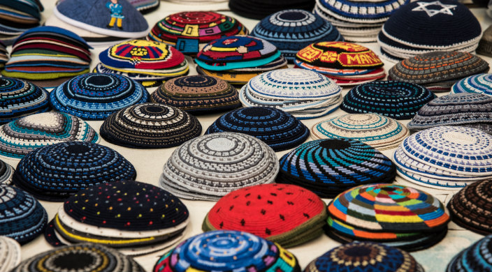 Assortment of knit kippot in piles on a table