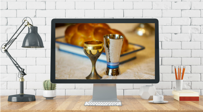 Home office setup with a Shabbat scene displayed on screen