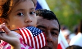 Little girl who adult holding an American flag