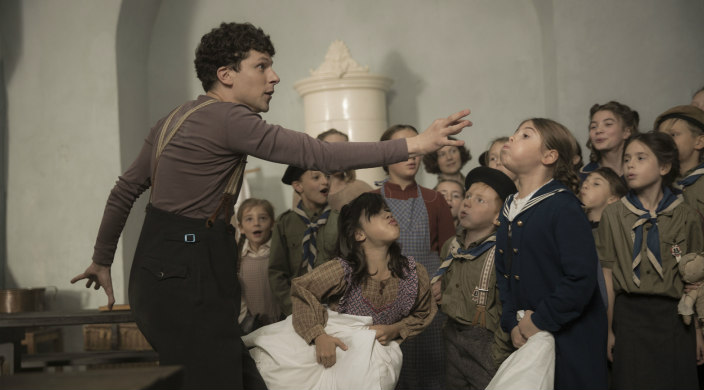 Still image from the film Resistance showing Jesse Eisenberg as Marcel Marceau engaging with a group of children
