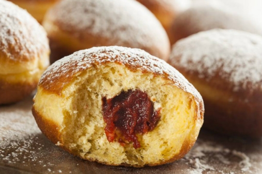 Sweet potato spiced sufganiyot with dark red jelly in the center