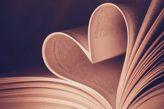 Close up of a book with a turned page formed into the shape of a heart