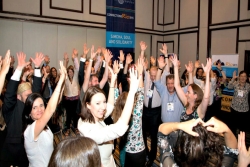 Group with their hands in the air as though celebrating at some sort of conference or convention