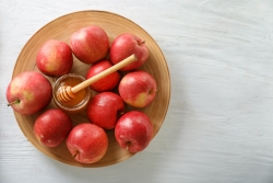 Bowl of apples with a small honey bowl in the center
