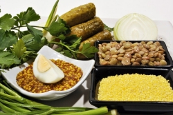 Sukkot foods including greens and lentils and an eggs and dolmas