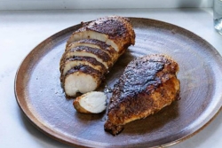 Coriander and Black Pepper Chicken breast sliced on a white plate