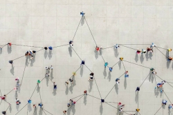 Aerial view of people standing spaced apart with line connecting them as if to represent connectivity despite distance