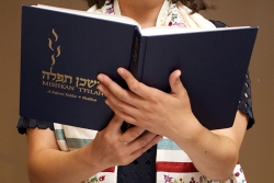 person reading from Mishkan Tfilah prayer book