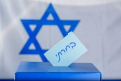 Blue ballot box in front of an Israeli flag 