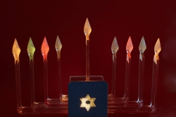 Electric menorah with colored lights against a red background