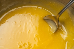 Silver spoon mixing an orange sauce