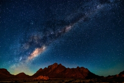 Starry night sky above desert geography