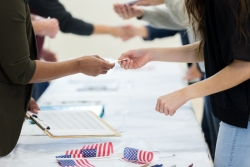 Multiple sets of hands over a voter registration table