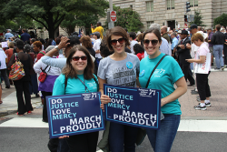 an image of three women holding signs that say "Do Justice, Love Mercy, March Proudly