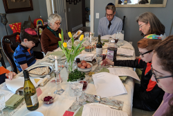 Photo of a group of people sitting down at a table for a Passover seder