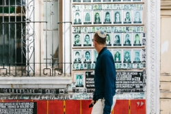 A man in a kippah walks by a wall of photos of people who disappeared during Guatemalas internal armed conflict