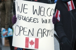Sign welcoming refugees with a Canadian flag