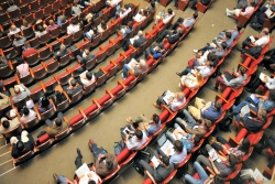 Aerial view of people seated in rows as at a conference or other large event