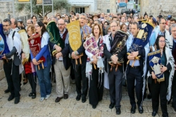 Group of dozens of rabbis and other Reform Jews holding Torah scrolls at the Western Wall while wearing prayer shawls