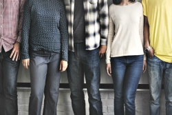Disembodied bodies of varying races standing against a wall in casual poses wearing casual clothing such as jeans and flannel shirts