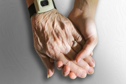 Closeup of and elderly woman and a young woman holding hands as though to represent caretaking