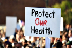 Protest sign reading PROTECT OUR HEALTH