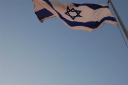 Israeli flag blowing against the blue sky