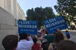 People marching with Love Thy Neighbor signs