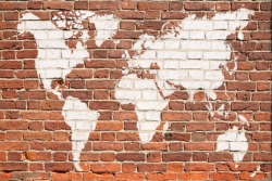 World map spray painted in white on a red brick wall