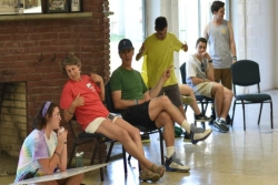 Peri Smilow sitting in a chair surrounded by Kutz campers and laughing 