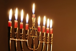 Gold menorah fully lit with red candles