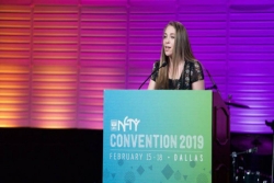 Sarah Friedman stands at a podium bearing the name NFTY Convention