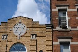 Brick synagogue building with a large stone Star of David above the door 