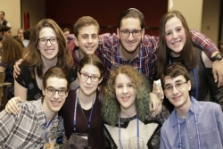 Group of smiling teens together at Shabbat dinner 