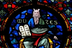 Colorful and intricate stained glass window depicting Moses holding the stone tablets of the Ten Commandments